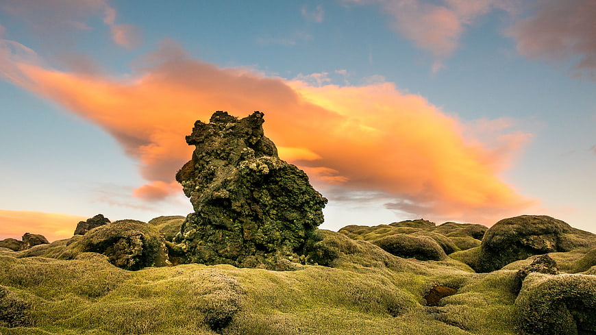 Dramatic Sunset Over Mossy Lava Rock Landscape