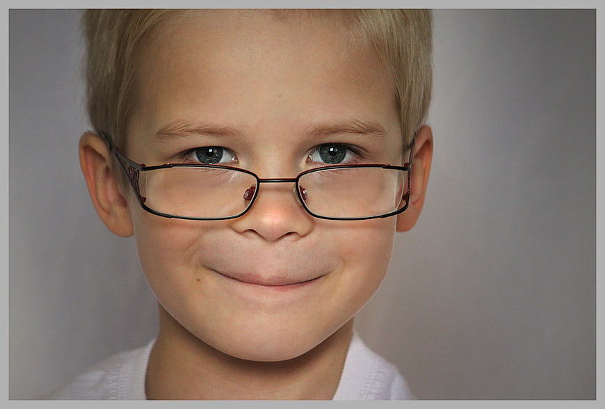 Portrait of a cute young boy with glasses smiling