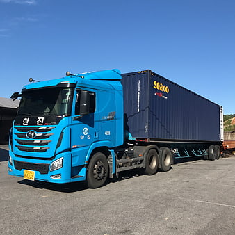 Blue Hyundai Xcient Truck Hauling Shipping Container