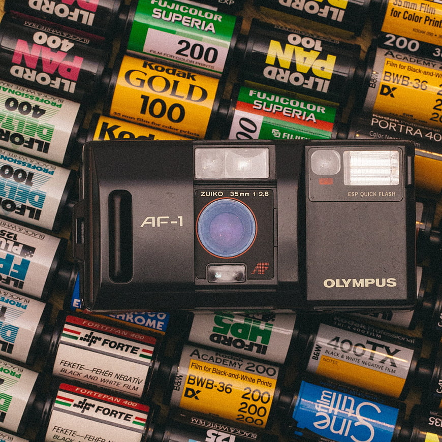 Vintage Olympus AF-1 Camera on Background of 35mm Film Rolls