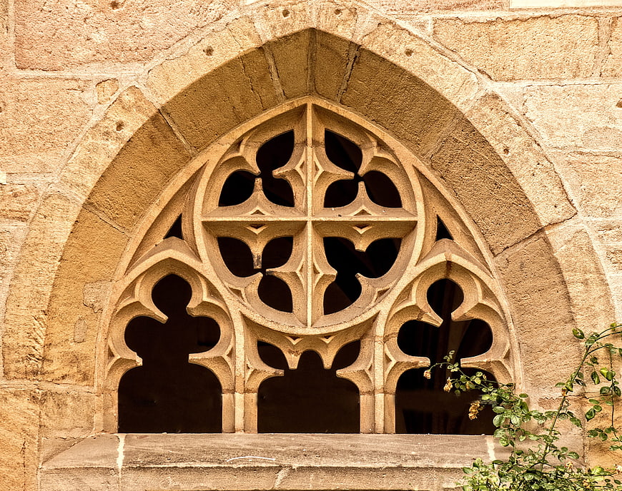 Gothic stone window tracery on historic monastery wall