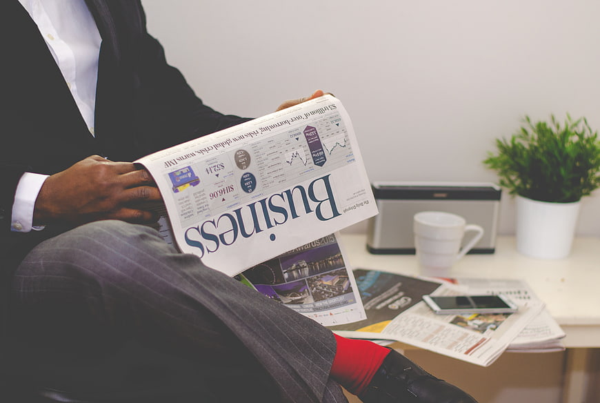 Businessman reading financial newspaper in office