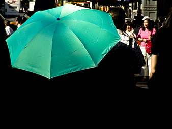 Teal Umbrella in Crowded Street Scene