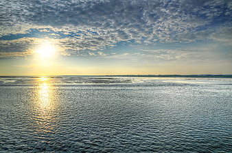 Sunset over Wadden Sea low tide with textured clouds