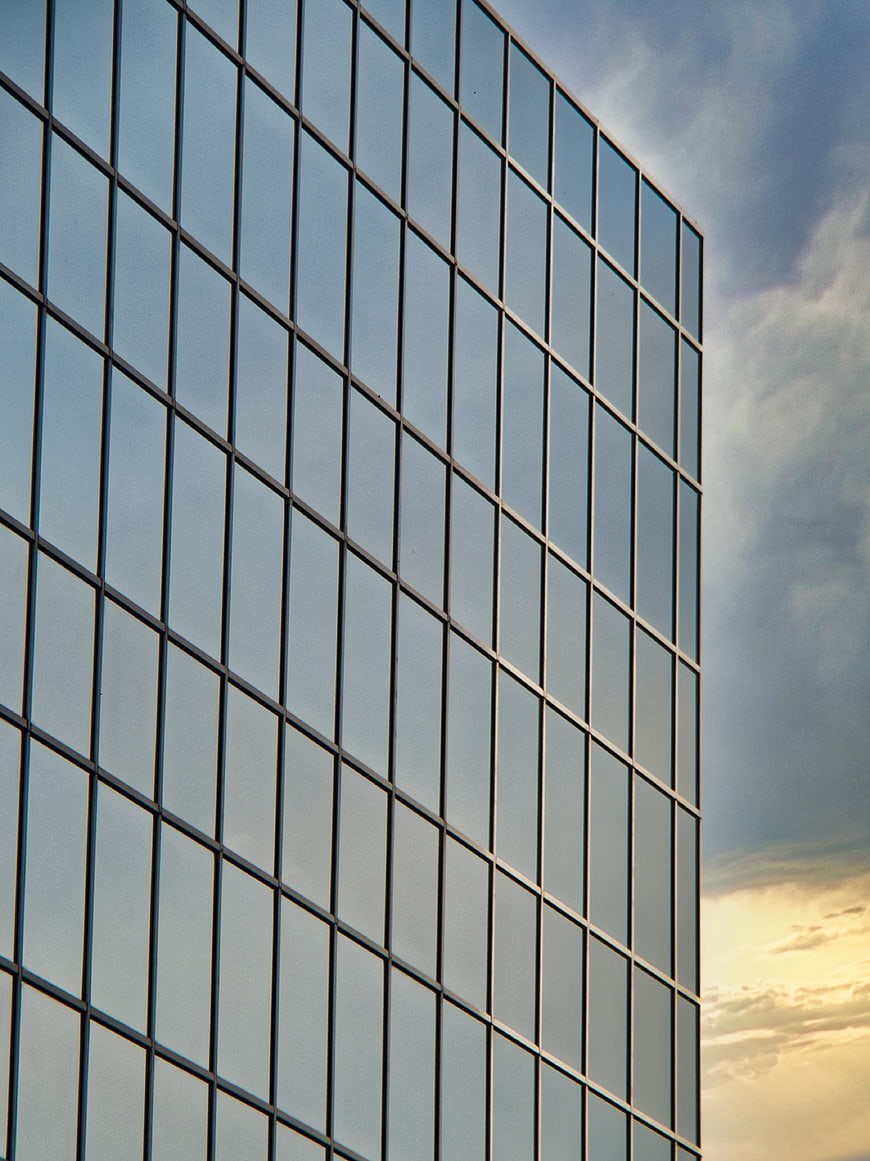 Modern Glass Office Building Facade with Sky Reflection
