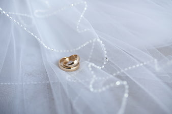 Gold wedding rings on white tulle fabric
