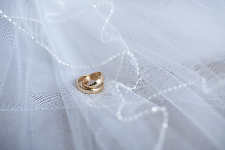 Gold wedding rings on white tulle fabric