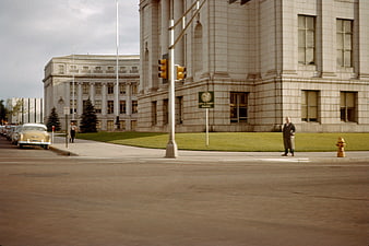 Vintage street scene with classic cars and city hall building
