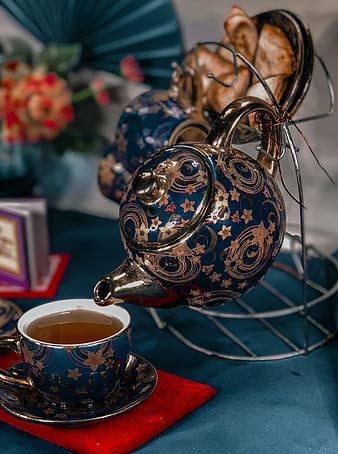 Traditional blue and gold teapot pouring tea into a cup