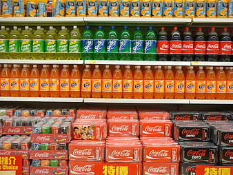 Supermarket shelves stocked with colorful soda bottles and cans