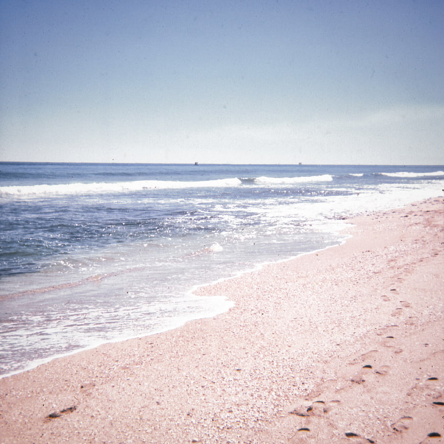 Vintage Film Photo of Pink Sand Beach and Blue Ocean Waves