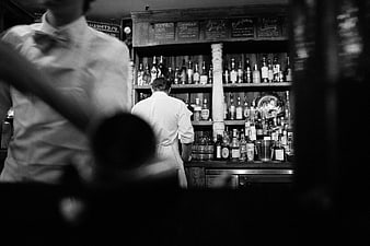 Bartenders working behind a busy bar counter
