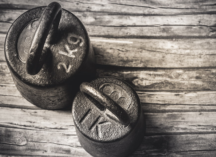 Vintage Cast Iron Weights on Rustic Wooden Background