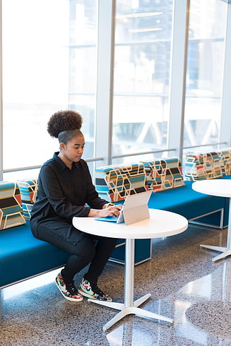 Young woman working on laptop in modern office lounge