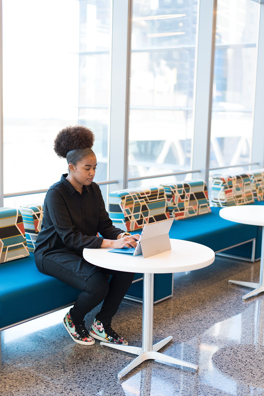 Young woman working on laptop in modern office lounge