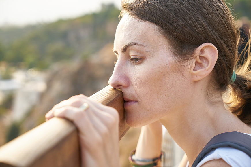 Emotional Close-Up Portrait of Woman Leaning on Wooden Railing