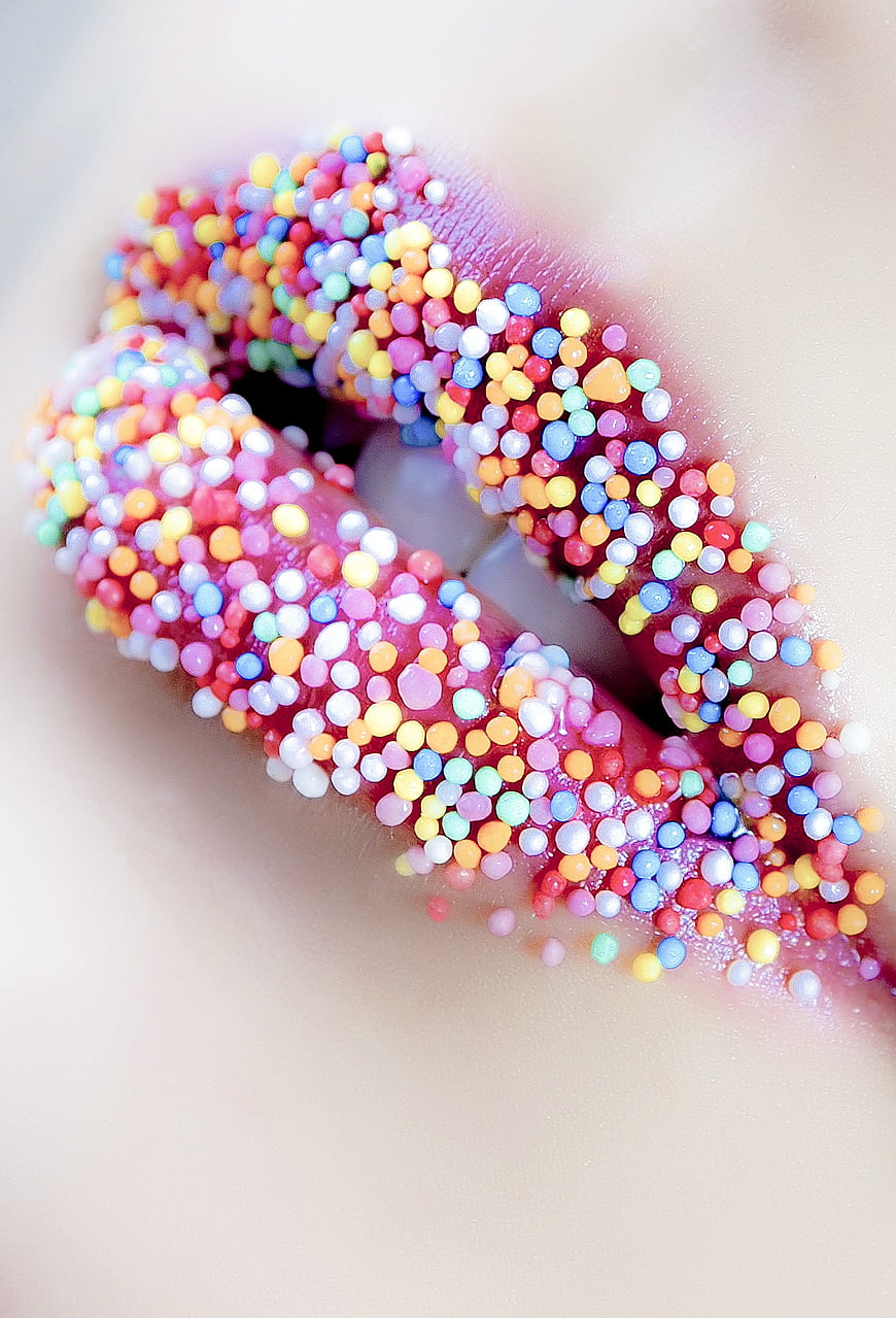Close-up of lips covered in colorful sprinkles