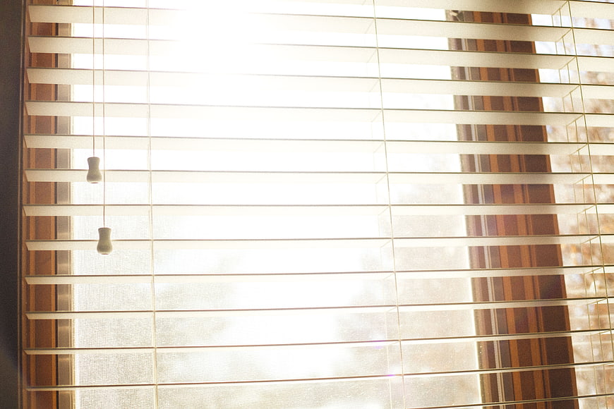 Bright Sunlight Streaming Through Horizontal Window Blinds