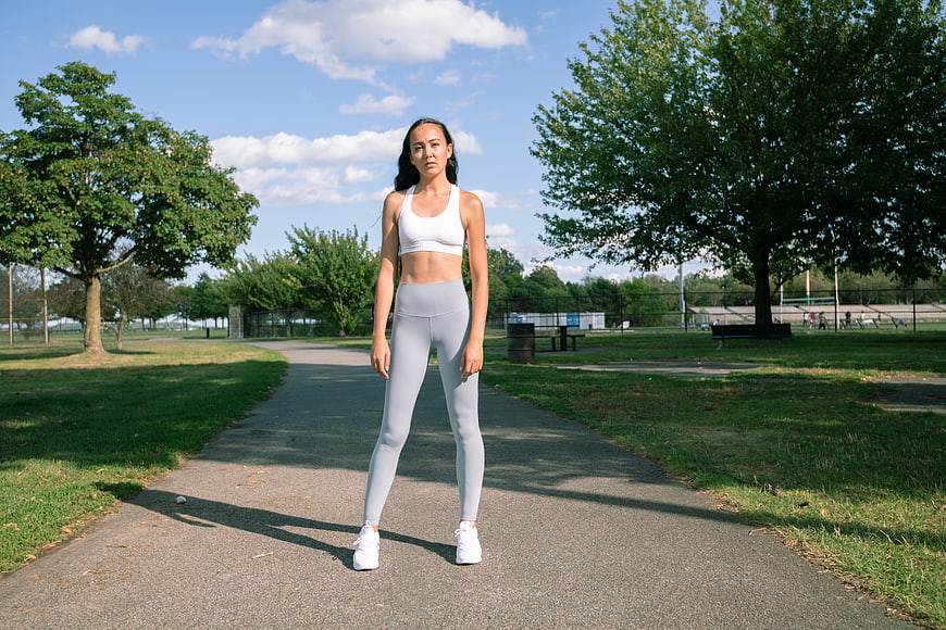Woman in athletic wear standing on park path