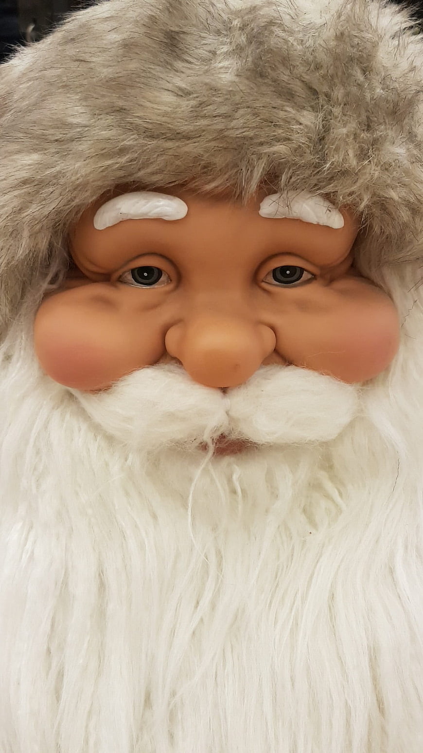 Close-up of a Santa Claus mask with white beard and fur hat