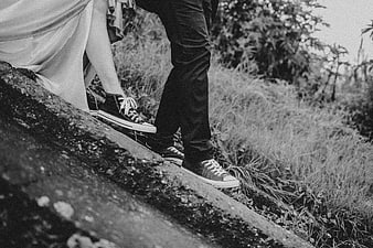Black and white photo of couple's legs walking on path