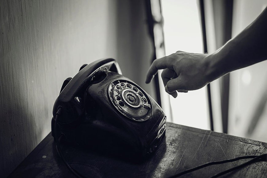 Hand Reaching for Vintage Rotary Telephone