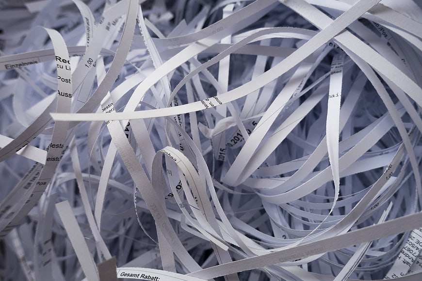 Close-up of shredded paper strips with visible text fragments