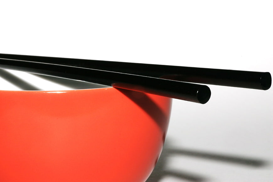 Black Chopsticks on Red Bowl with White Background