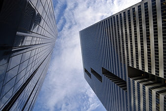 Low angle view of modern glass skyscrapers against blue sky