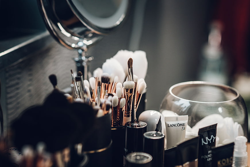 Professional Makeup Brushes And Lancome Cosmetics On Vanity Table