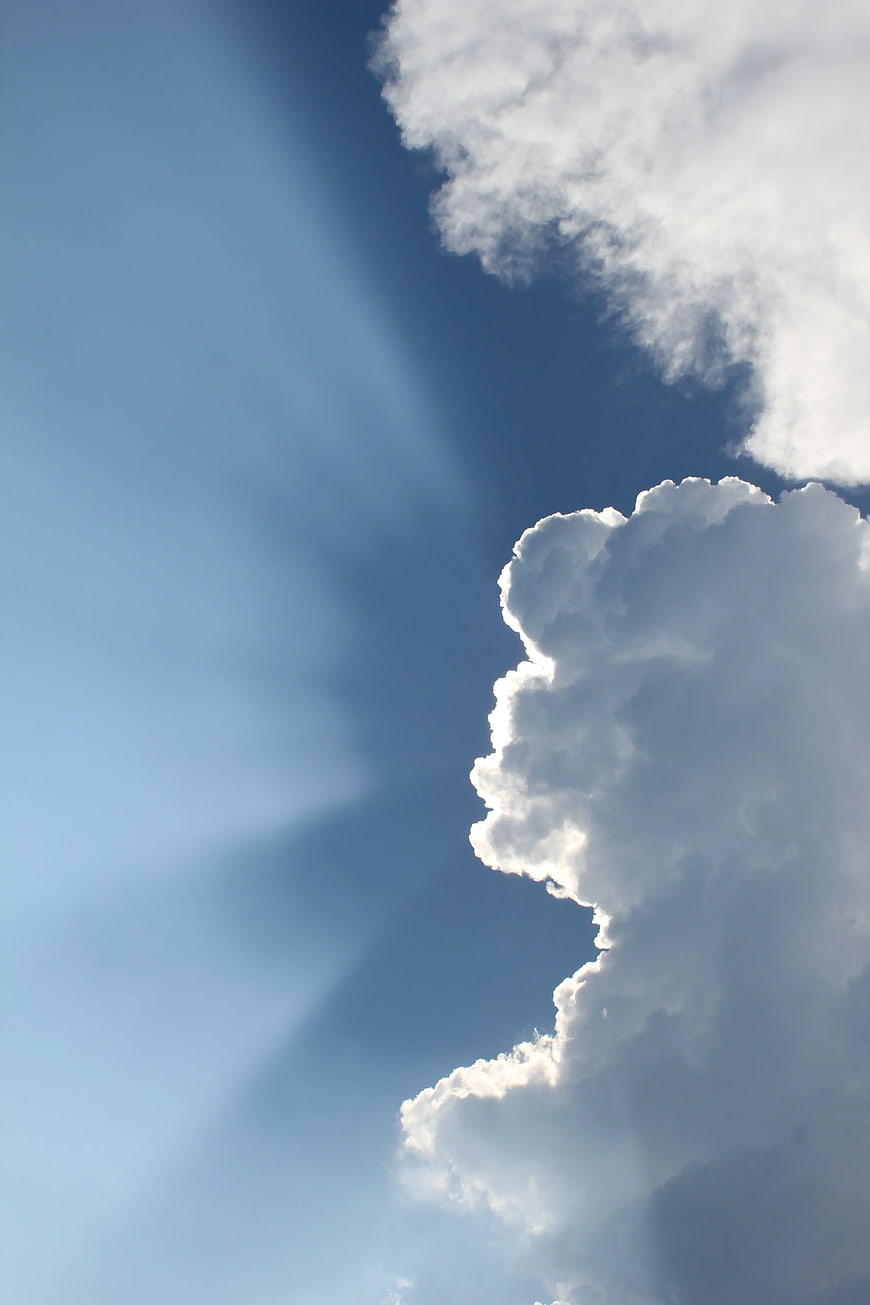 Dramatic Sun Rays Through Clouds in Blue Sky