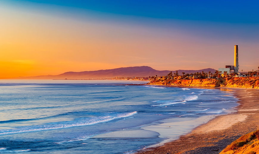 Sunset coastal landscape with ocean waves and cliffs