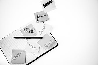 Black and white notebook with sticky notes and pen