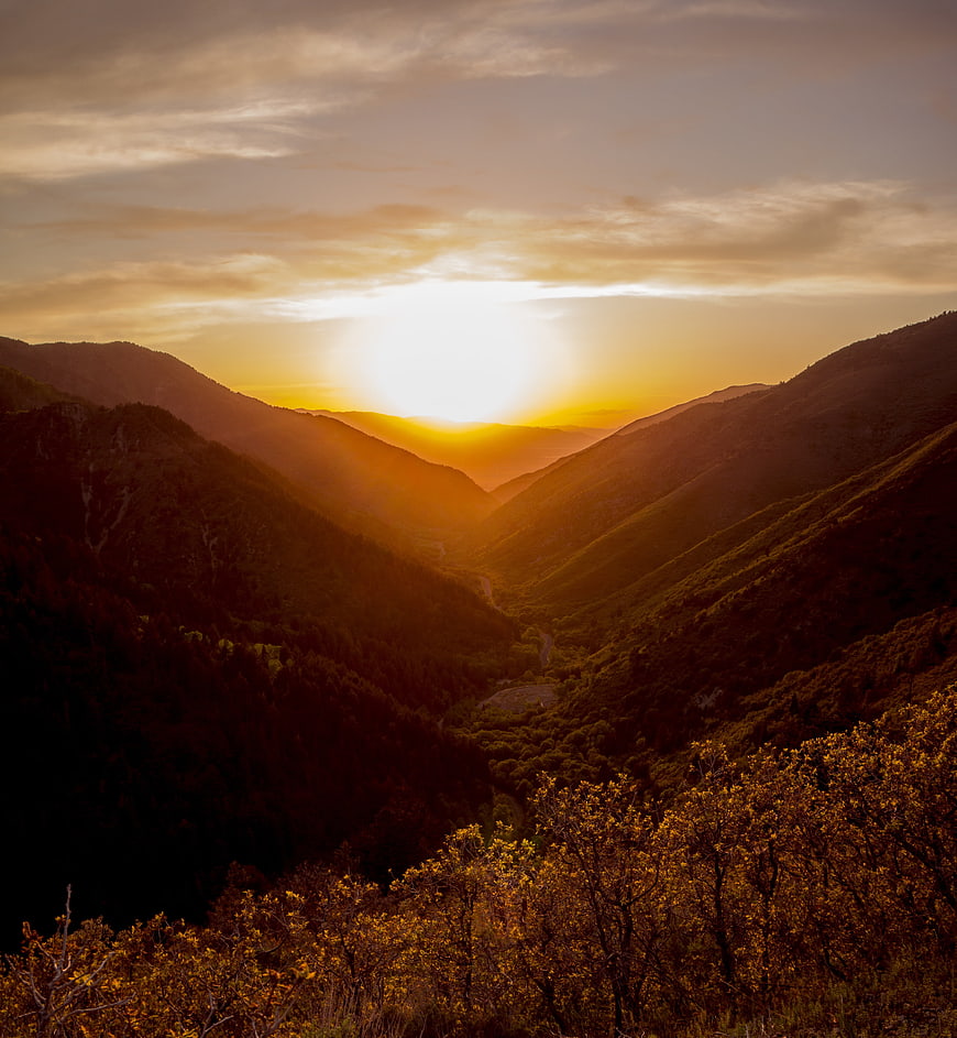 Golden sunset over mountain valley with winding road
