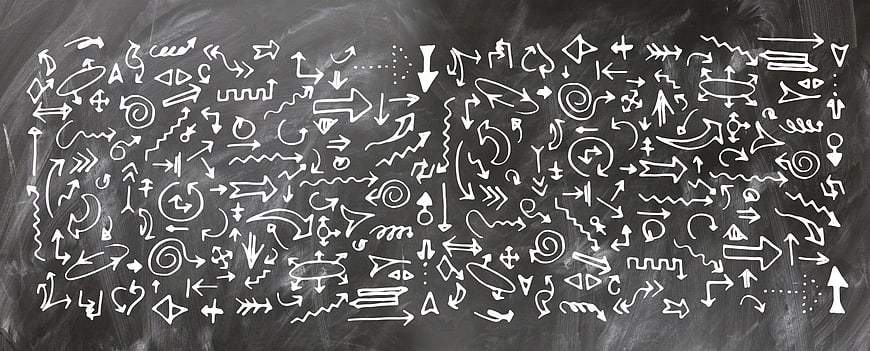 Hand-drawn white chalk arrows and symbols on a dark blackboard background
