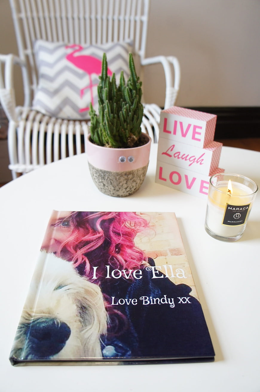Personalized photo book with pink hair and dog on white table