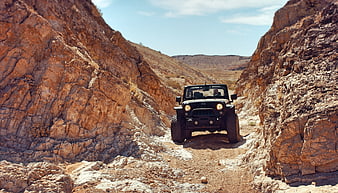 Black Jeep Wrangler Off-Roading Through Rocky Desert Canyon
