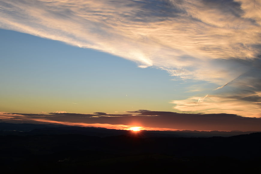 Dramatic sunset over mountain landscape with golden clouds