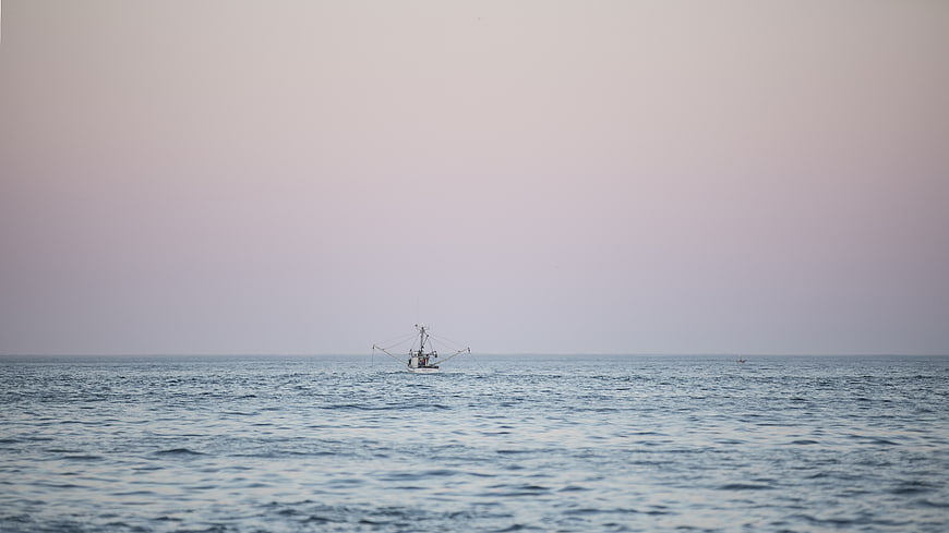 Lone Fishing Boat on Calm Ocean Horizon