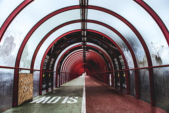 Red arched pedestrian tunnel with slow marking