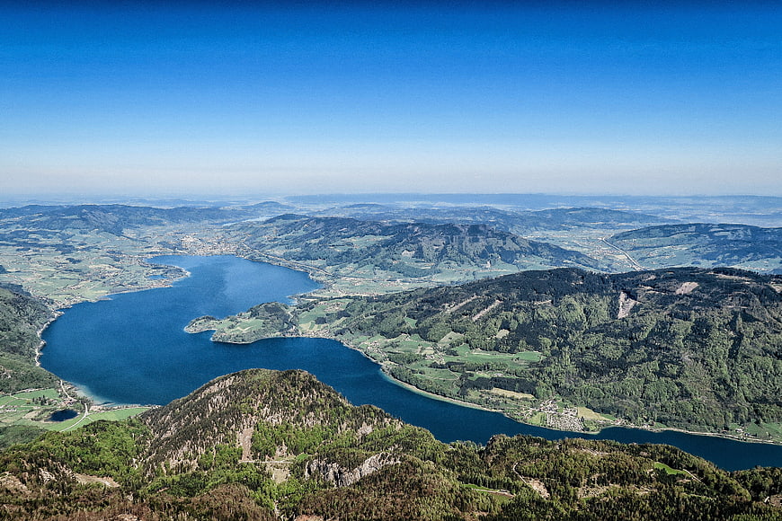 Aerial view of blue lake surrounded by green mountains