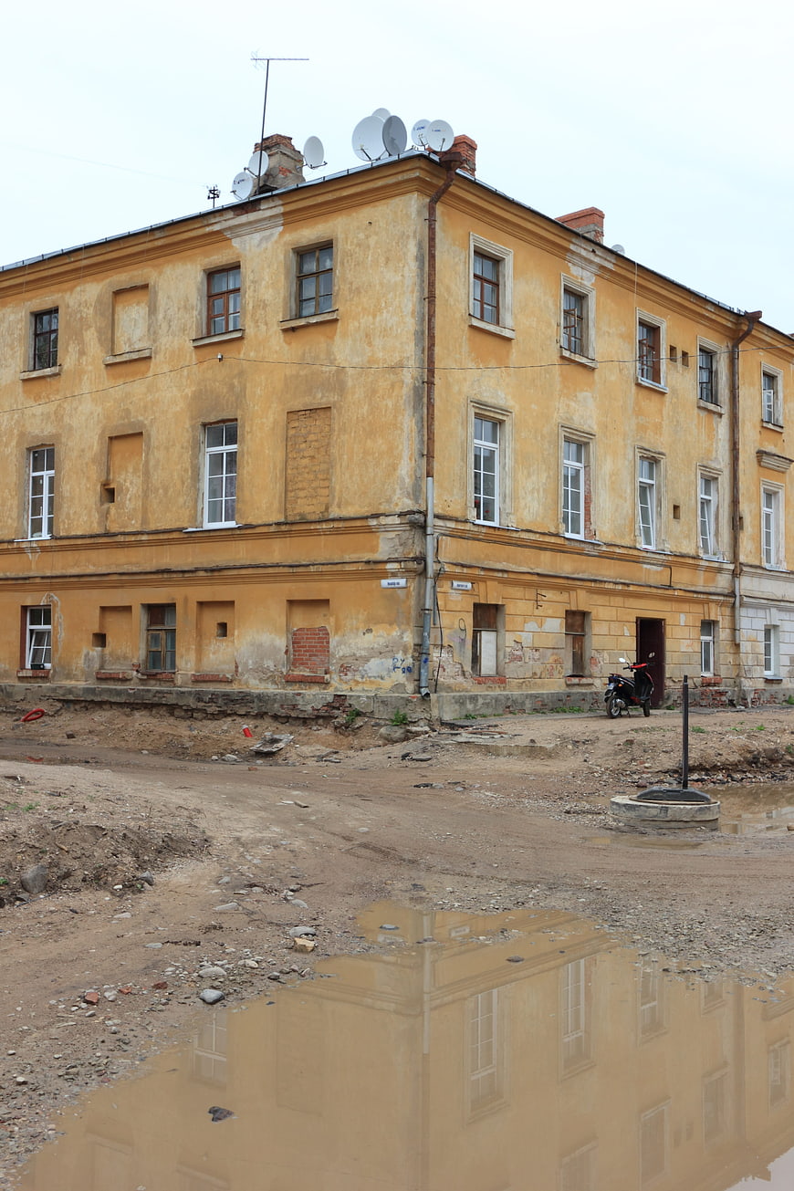 Old yellow building with puddle reflection in Latvia