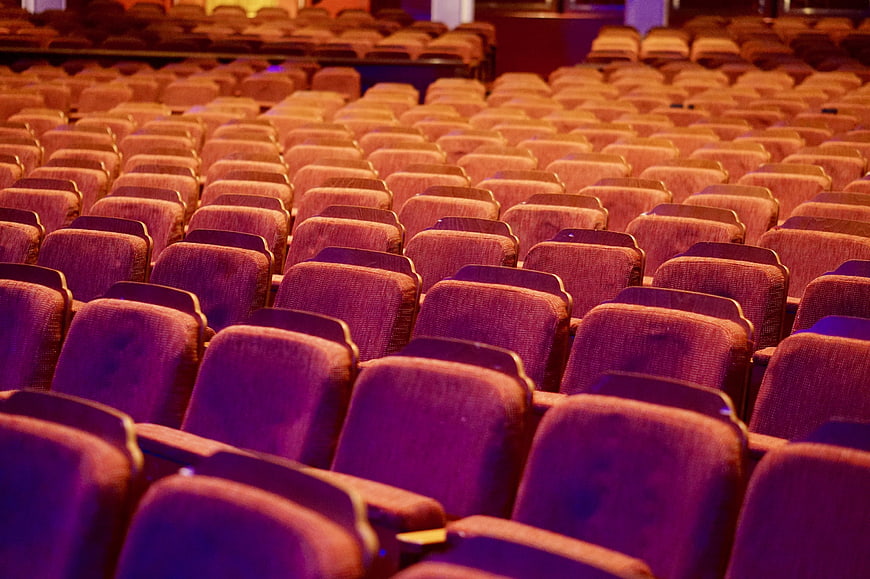 Empty Theater Auditorium With Rows Of Purple And Orange Seats
