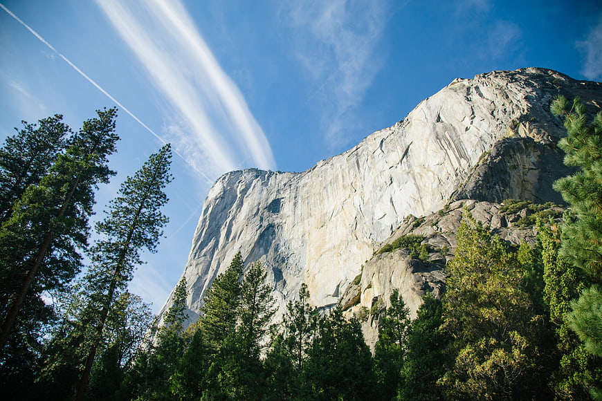 Majestic granite mountain peak rising above pine forest