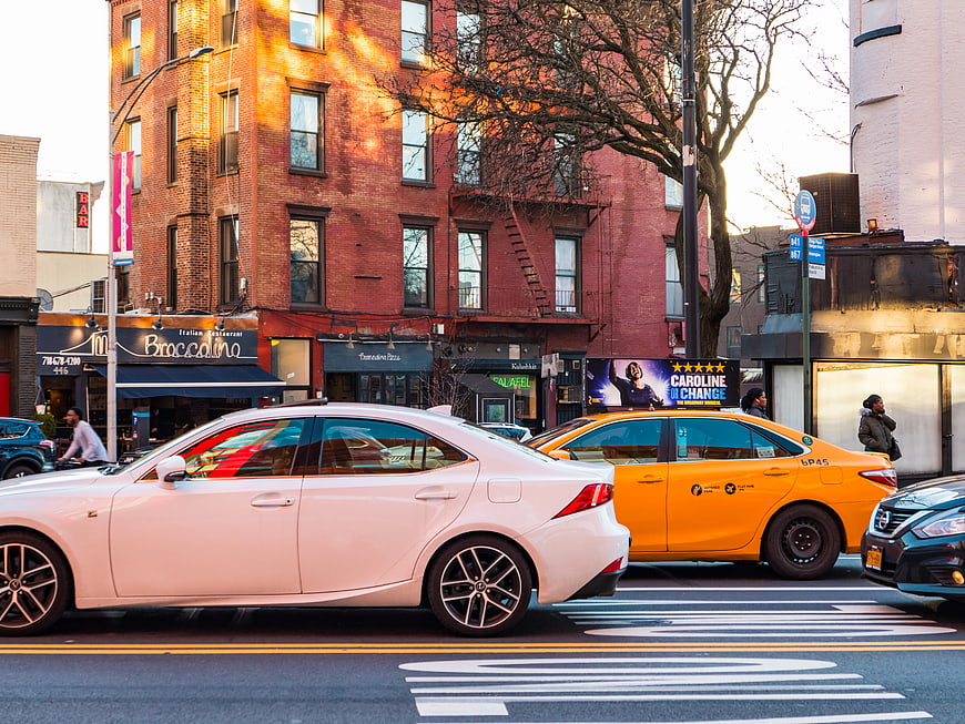 White Sedan and Yellow Taxi on Brooklyn City Street