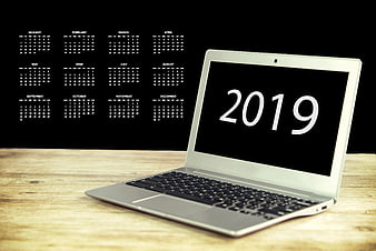 Laptop displaying 2019 on screen with calendar grid on black background
