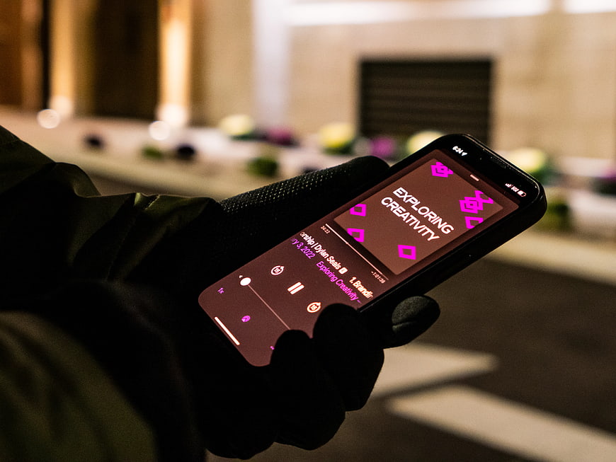 Hand in Black Glove Holding Smartphone Playing Podcast