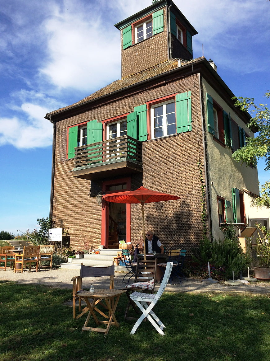 Traditional half-timbered house with green shutters and outdoor seating