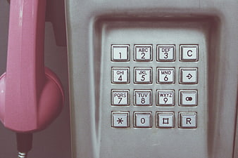 Close-up of vintage pink payphone keypad with retro buttons