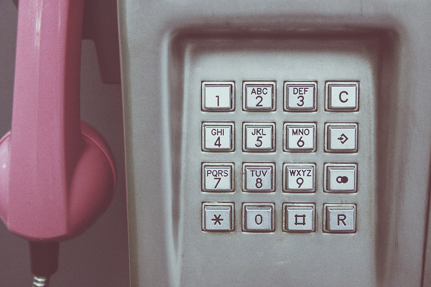 Close-up of vintage pink payphone keypad with retro buttons